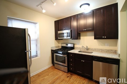 A kitchen with black cabinets and stainless steel appliances.