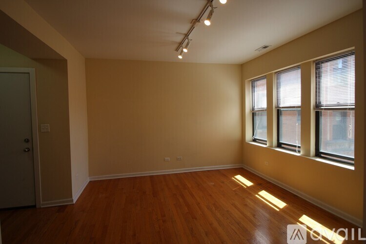 A room with wooden floors and a door on the left.