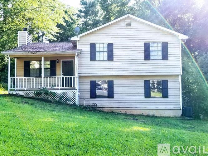 A two-story house with a porch and a chimney.