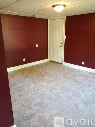 A room with a white door and a tiled floor.