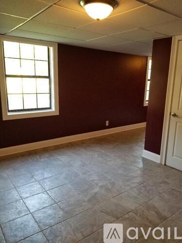 A room with a window and tiled floor.
