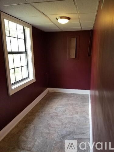 A room with a window and tiled floor.