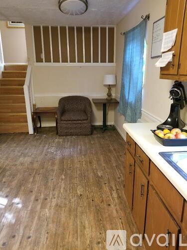 A kitchen with wooden floors and a brown chair.