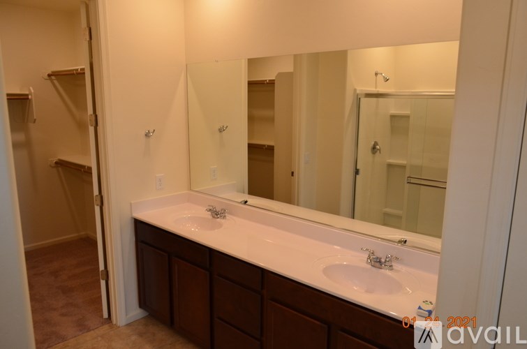 A bathroom with a double sink vanity and a large mirror.