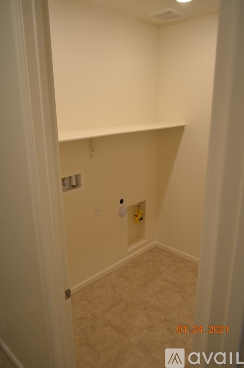 A small empty room with a light switch and a wall socket.