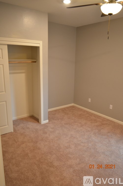 A room with a ceiling fan and a carpeted floor.
