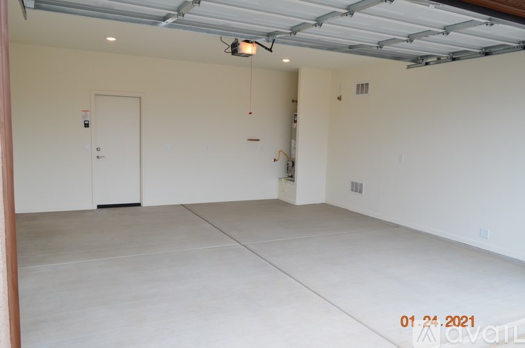 A large empty room with a door and a window.