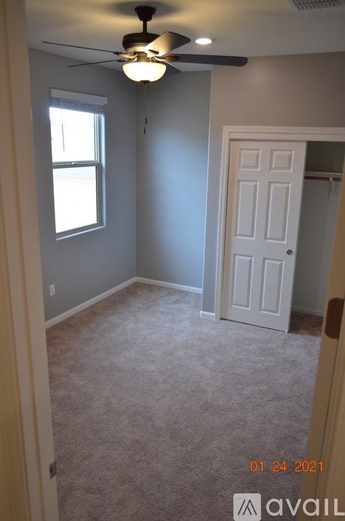 A room with a ceiling fan and a door.