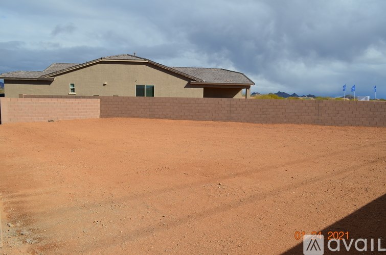 A house with a brown roof and a brown wall is in the desert.