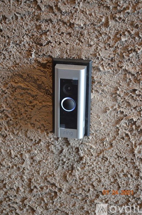 A security camera is mounted on a textured wall.