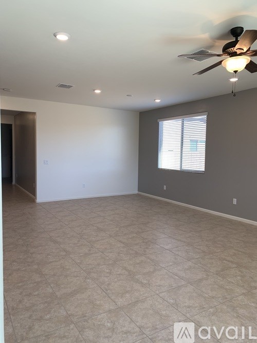 A spacious room with a ceiling fan and tiled floor.