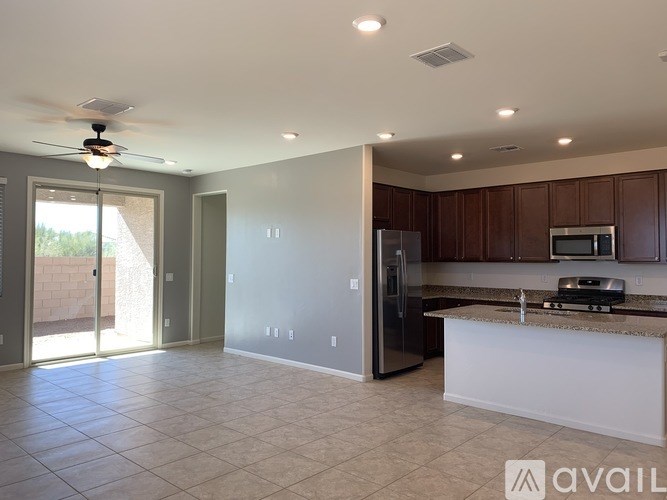 A kitchen with a refrigerator, microwave, and oven is available for rent.