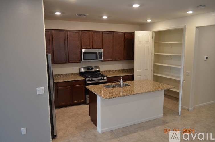 A kitchen with brown cabinets and a granite countertop.