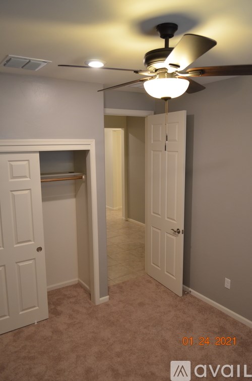 A room with a ceiling fan and a carpeted floor.