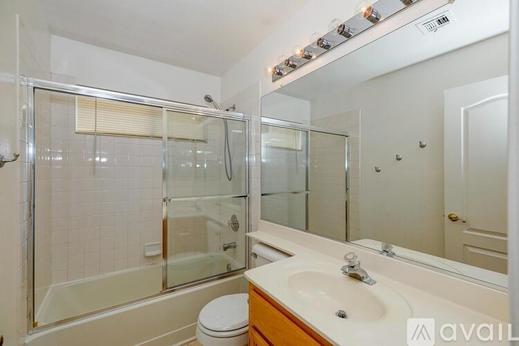 A bathroom with a glass shower stall and a sink.