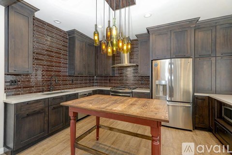 A kitchen with wooden cabinets and a wooden table.