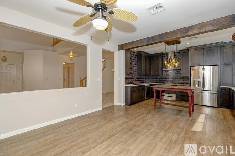 A spacious room with a wooden floor and a ceiling fan.