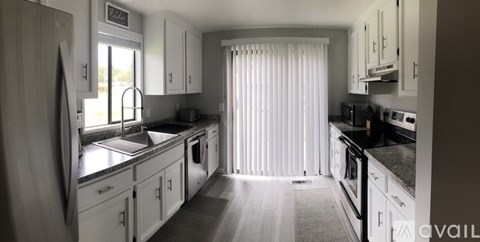 A kitchen with white cabinets and a black countertop.