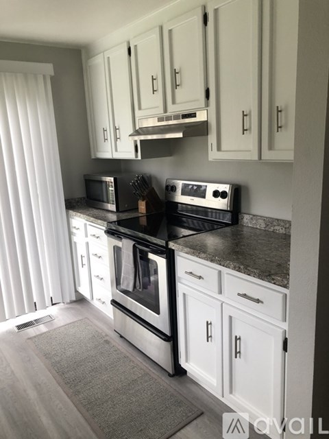 A kitchen with white cabinets and stainless steel appliances.