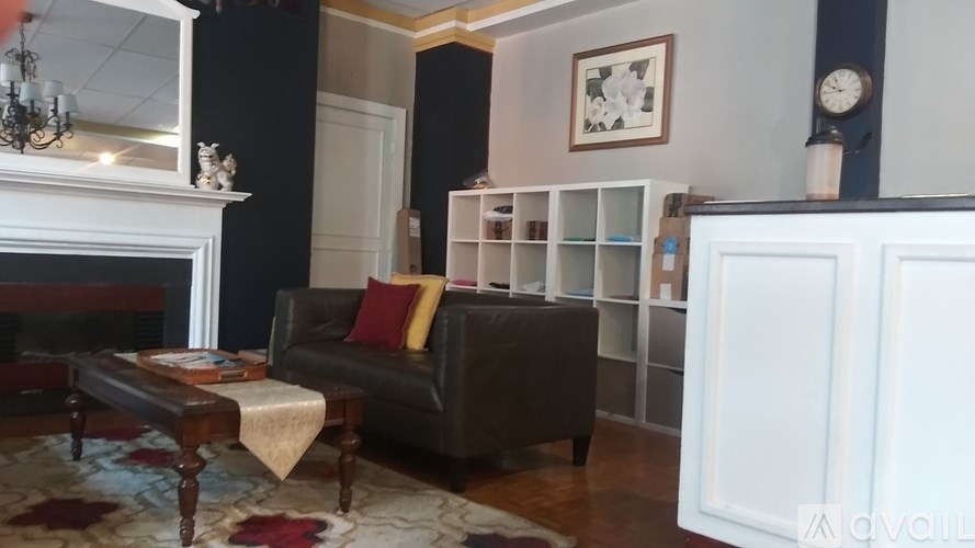 A living room with a brown couch and a fireplace.