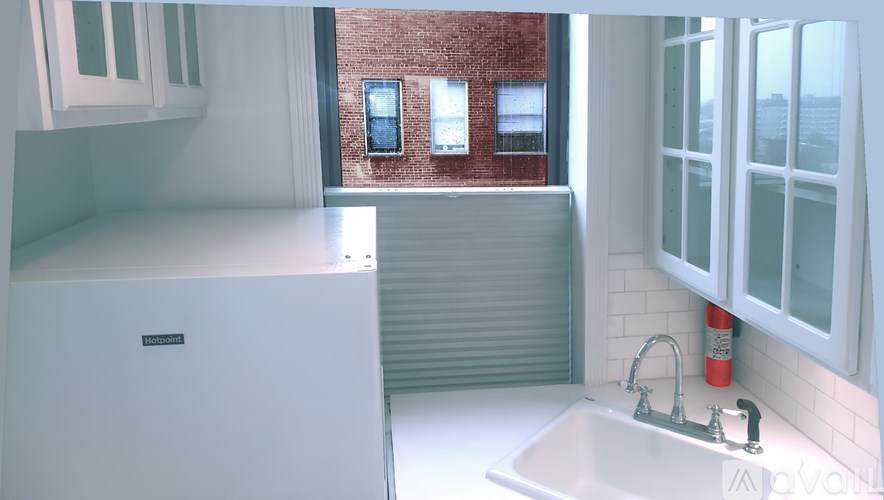 A room with a window and a lamp on the side table.