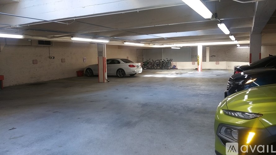 A car is parked in a garage with a bicycle in the background.