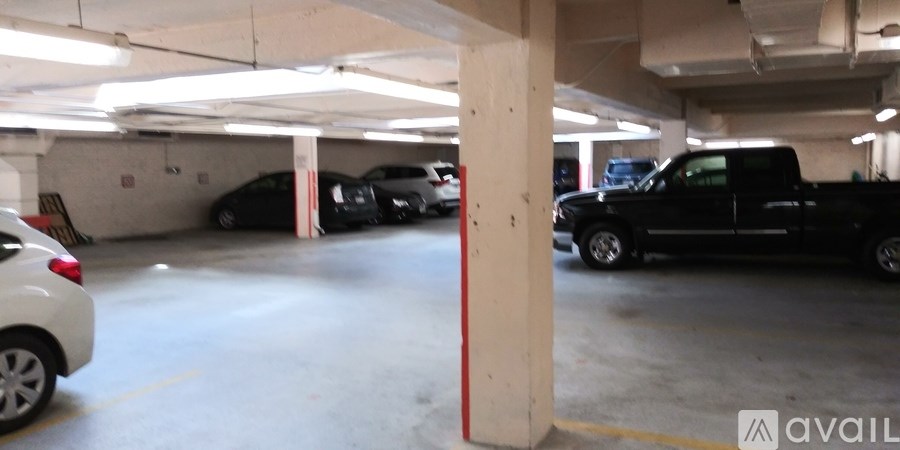 A parking garage with a white car on the left and a black truck on the right.