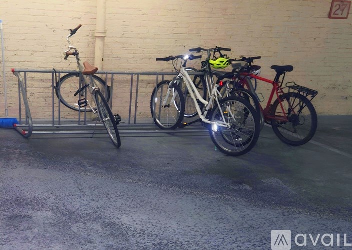 Three bicycles are parked next to a wall.