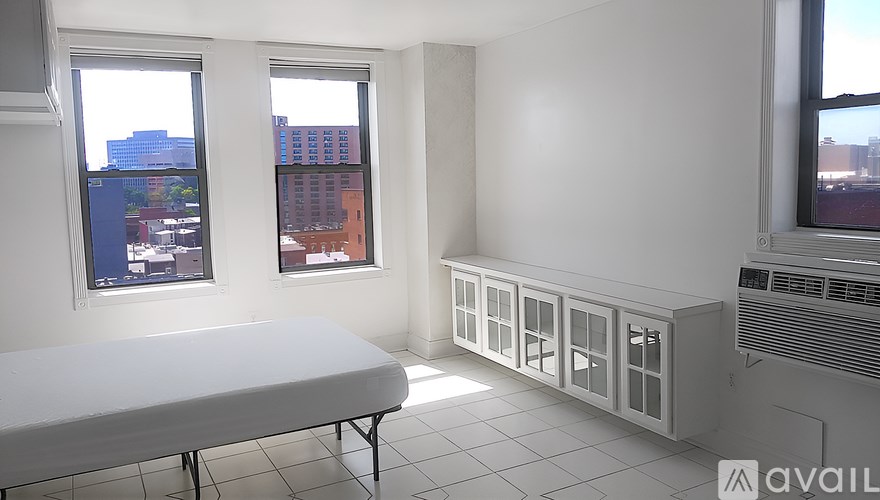 A tall red brick building with many windows is seen from the street.