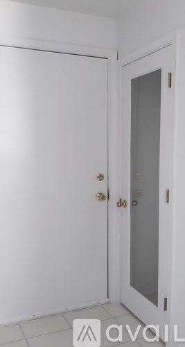 A white door with a glass panel and a gold handle.