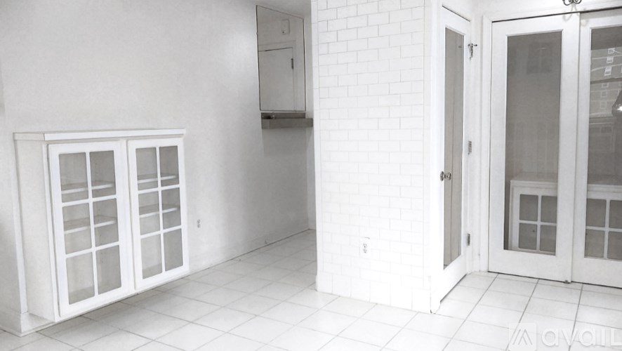A white interior with a glass door and a tiled floor.