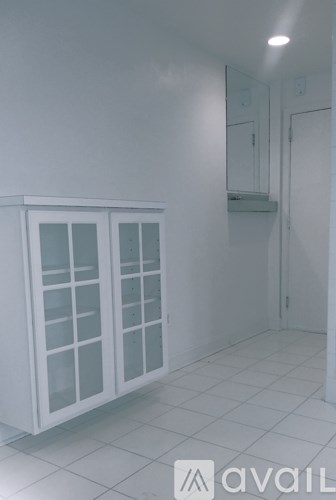 A white room with a cabinet and glass doors.