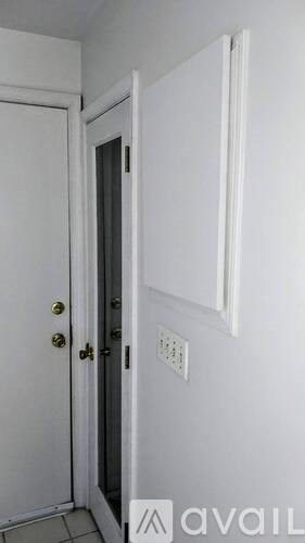 A white door with a gold handle is open.