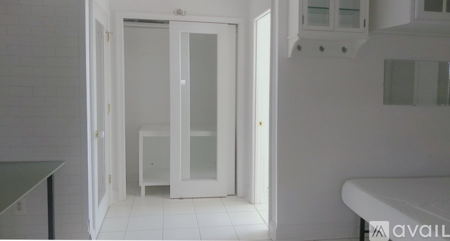 A white bathroom with a glass shower door and a white bathtub.