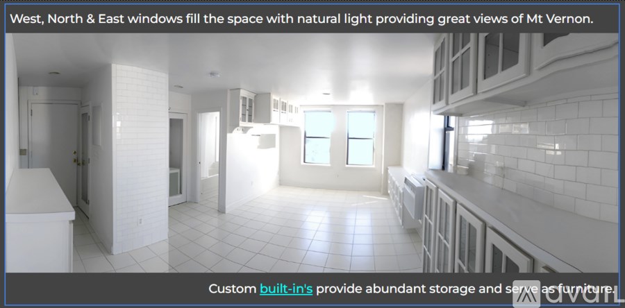 A kitchen with white cabinets and a tiled floor.
