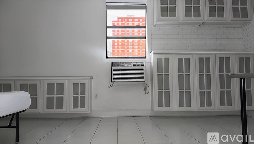 A tall red brick building stands in the middle of a street.