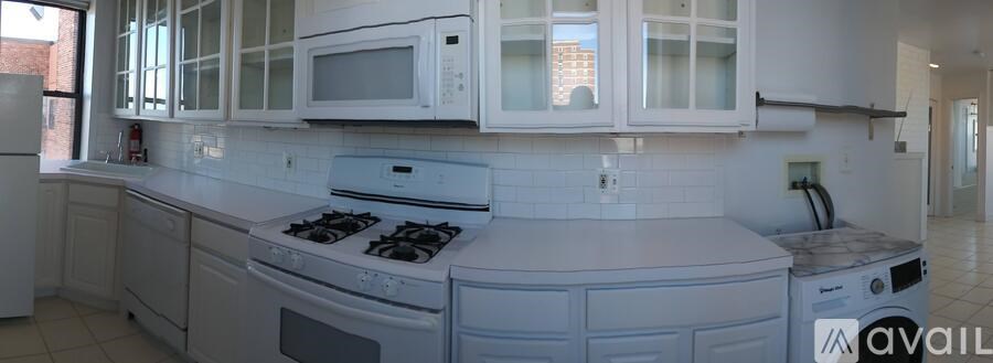 A kitchen with white appliances and cabinets.
