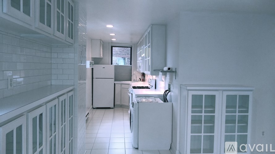 A kitchen with white appliances and cabinets.