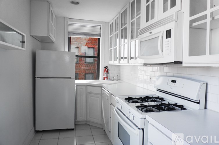 A kitchen with white appliances and cabinets.