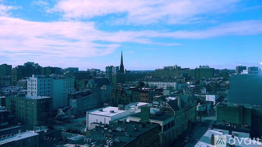 A cityscape with a church spire in the distance.