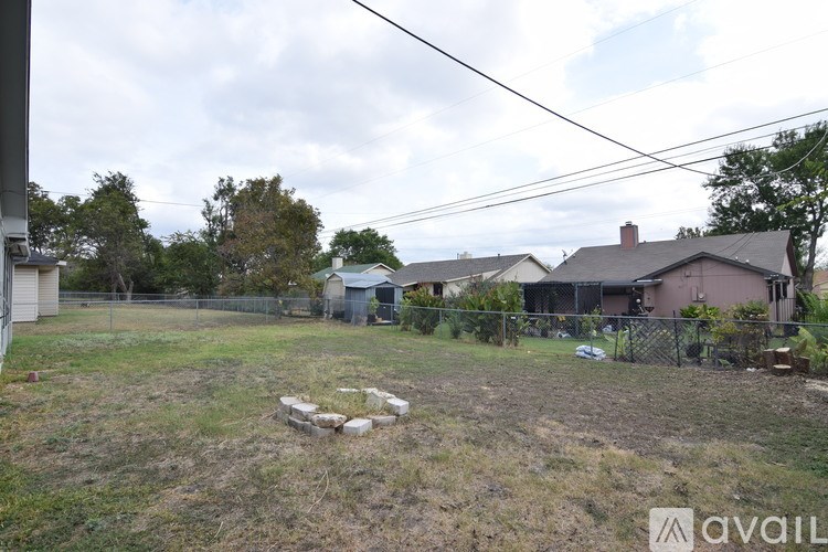 A backyard with a fence and a few trees.