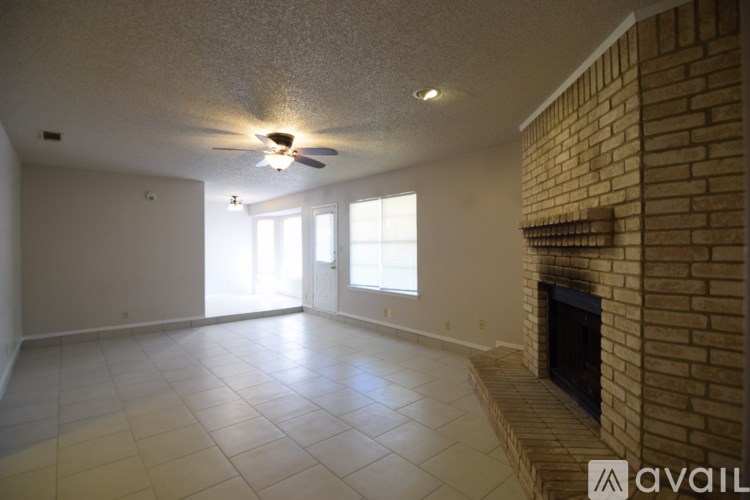 A living room with a fireplace and a ceiling fan.