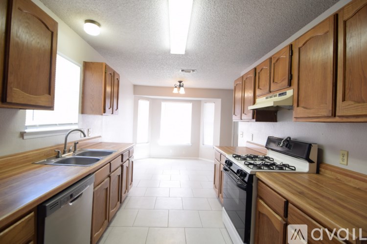 A kitchen with wooden cabinets and a white tile floor.
