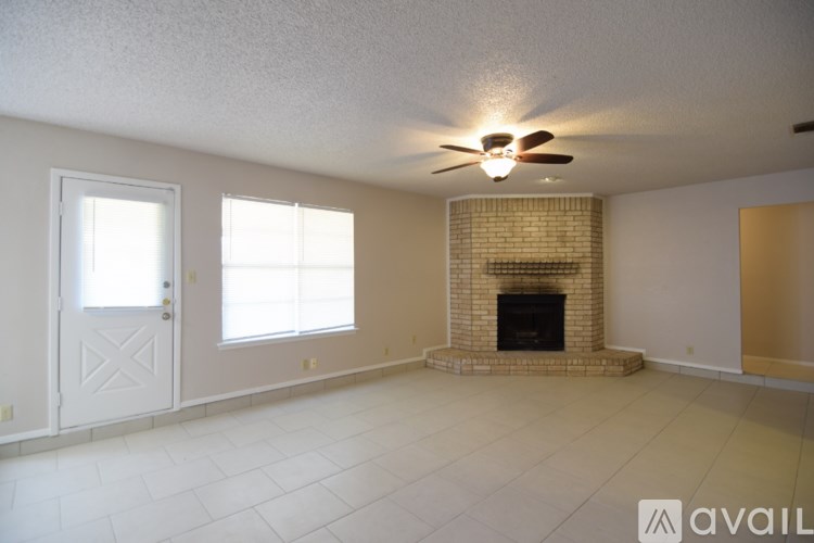 A living room with a fireplace and a ceiling fan.