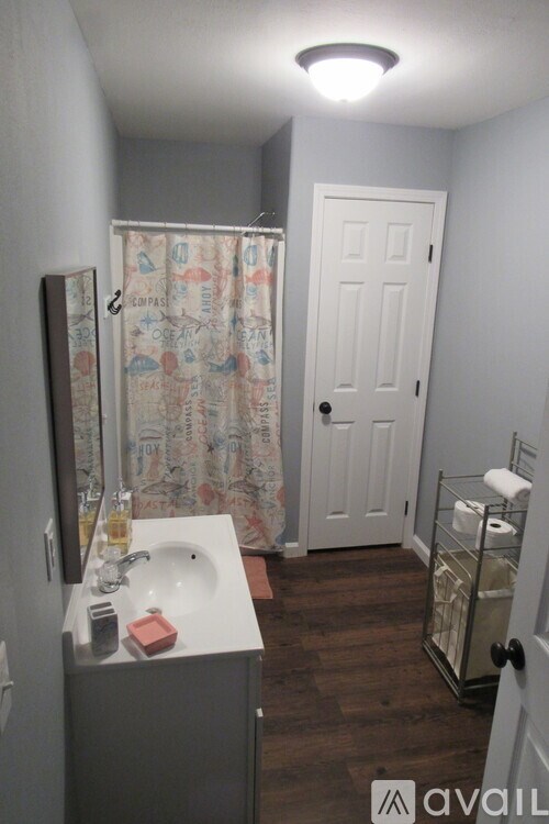 A bathroom with a sink, mirror, and toiletries.