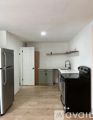 A kitchen with a black stove top oven and a black refrigerator.