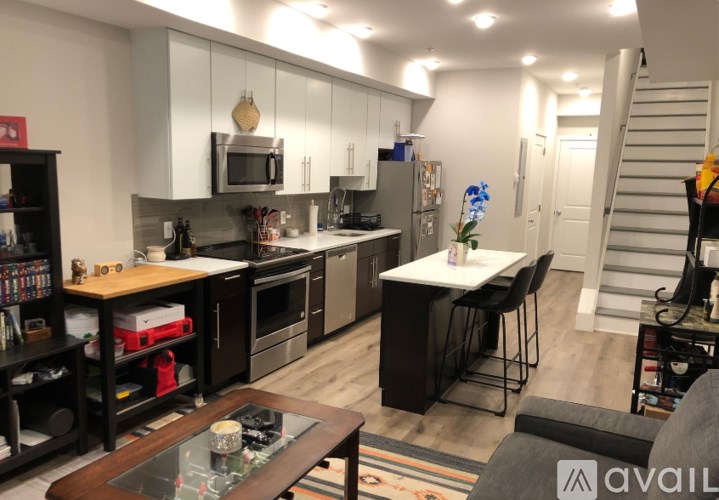 A kitchen with a refrigerator, microwave, oven, and sink.