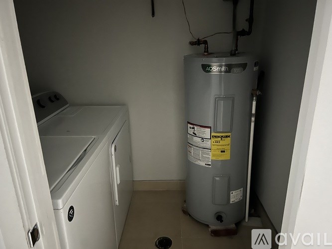 A bathroom with a toilet, sink, and a picture on the wall.