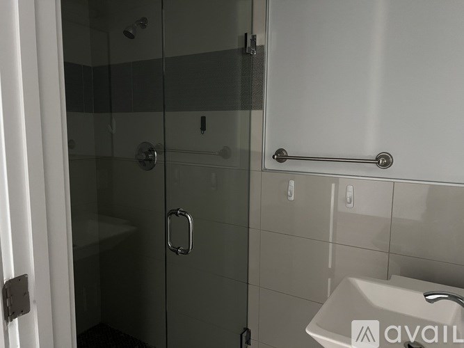 A bathroom with a glass shower door and a striped towel.