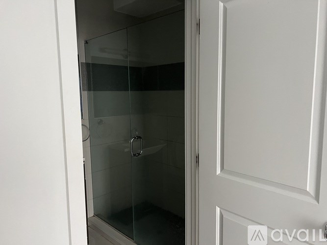 A staircase with a black handrail and white steps leading to a doorway.